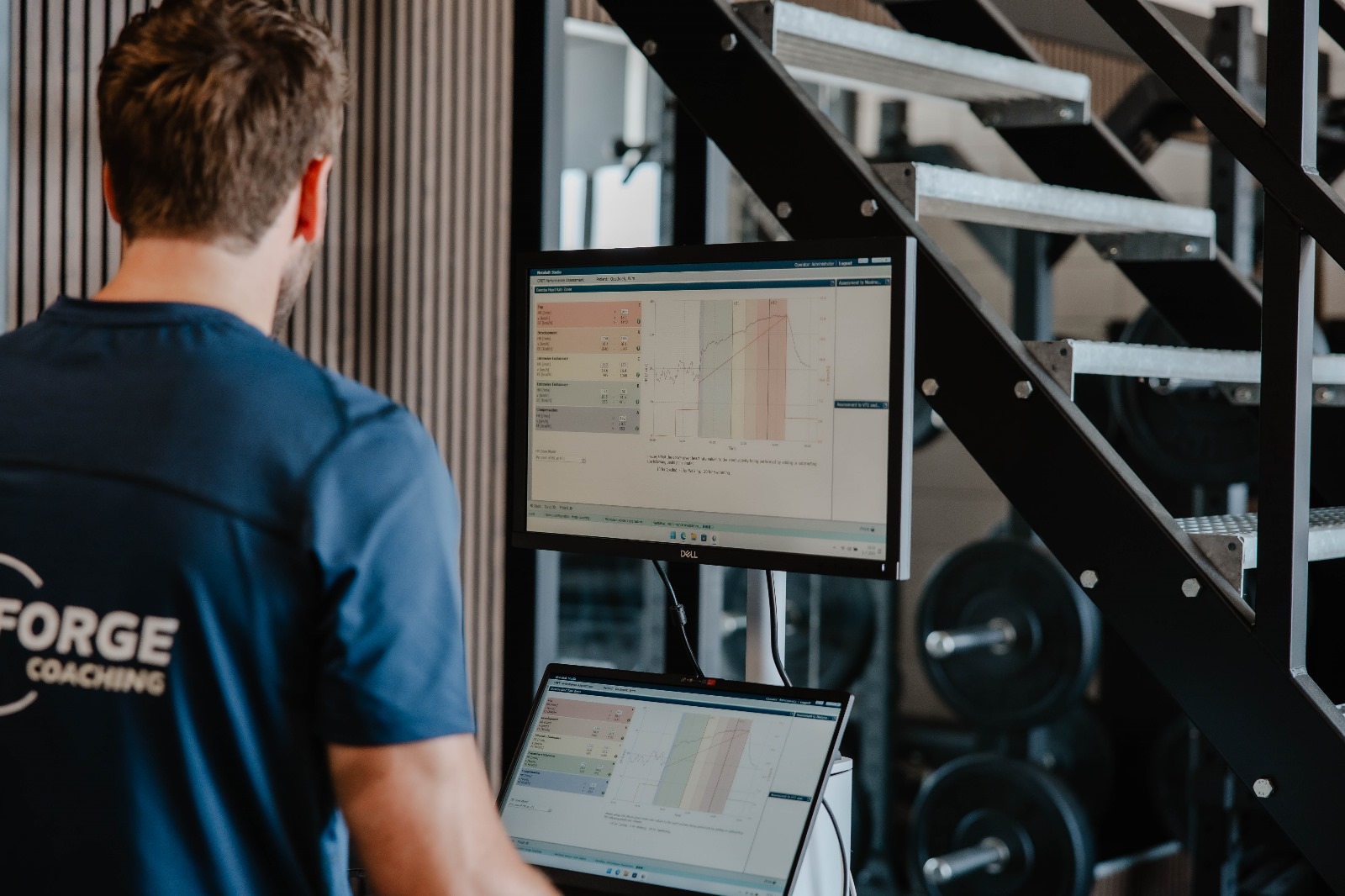 Coach analyseert testdata op een scherm tijdens een inspanningstest