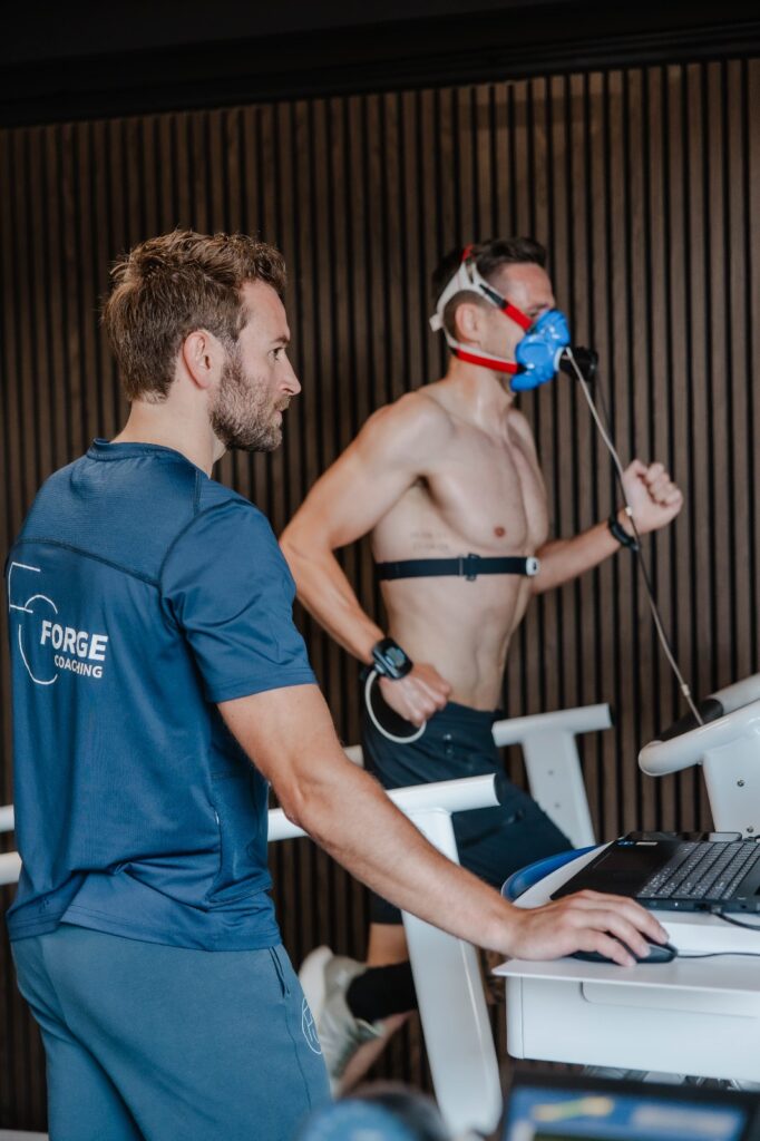 Jorrick begeleidt een sporter met ademgasmasker tijdens een inspanningstest