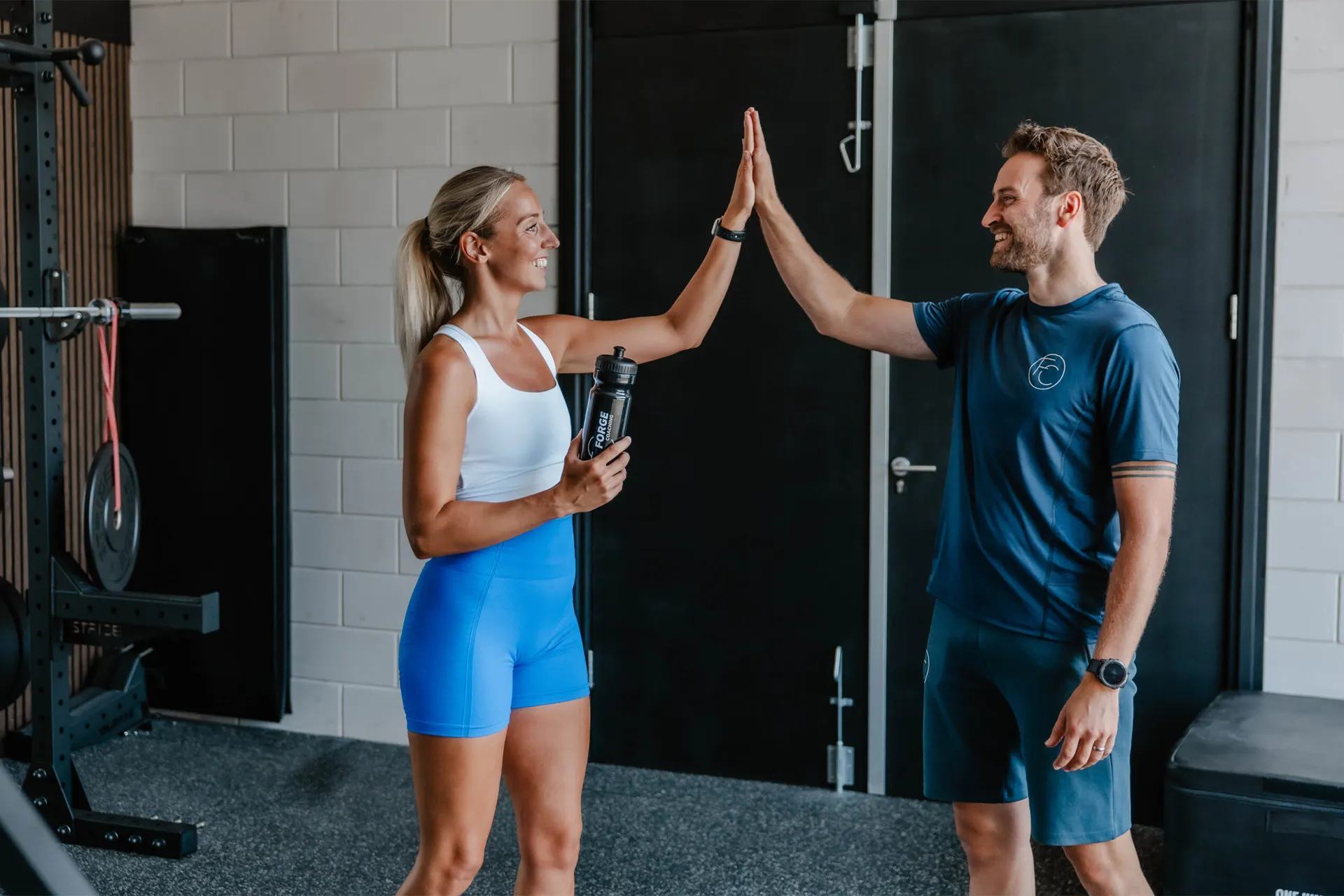 Jorrick en een sporter geven elkaar een high five in de trainingsruimte